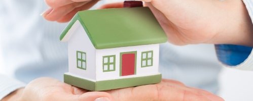 אדם שומר על דגם של בית בידיו