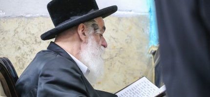 אדם חרדי מתפלל בבית כנסת