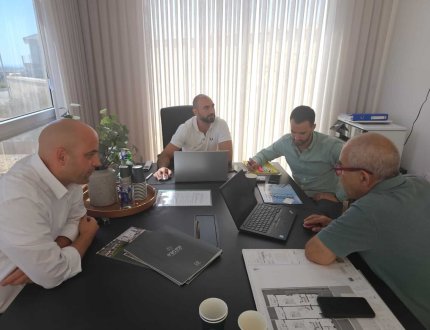 רישרד הננפלד, יועץ משכנתאות, בפגישת ייעוץ עם נציגי חברת בנייה במשרדיהם, לקראת לקיחת משכנתא לפרויקט נדל"ן בתל אביב