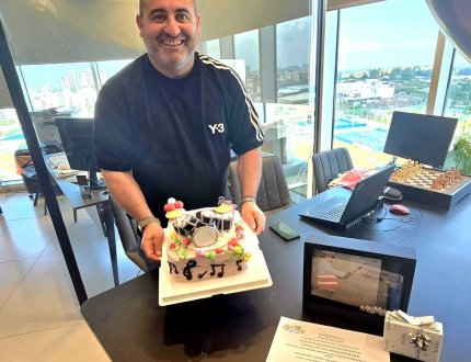 אלירן שותף במיקוד משכנתאות מחזיק עוגה באירוע של החברה